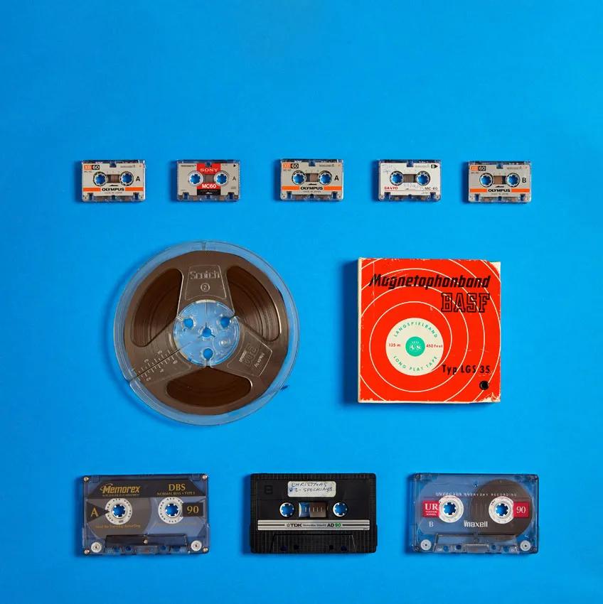 Audio reels and audio cassettes on a blue background